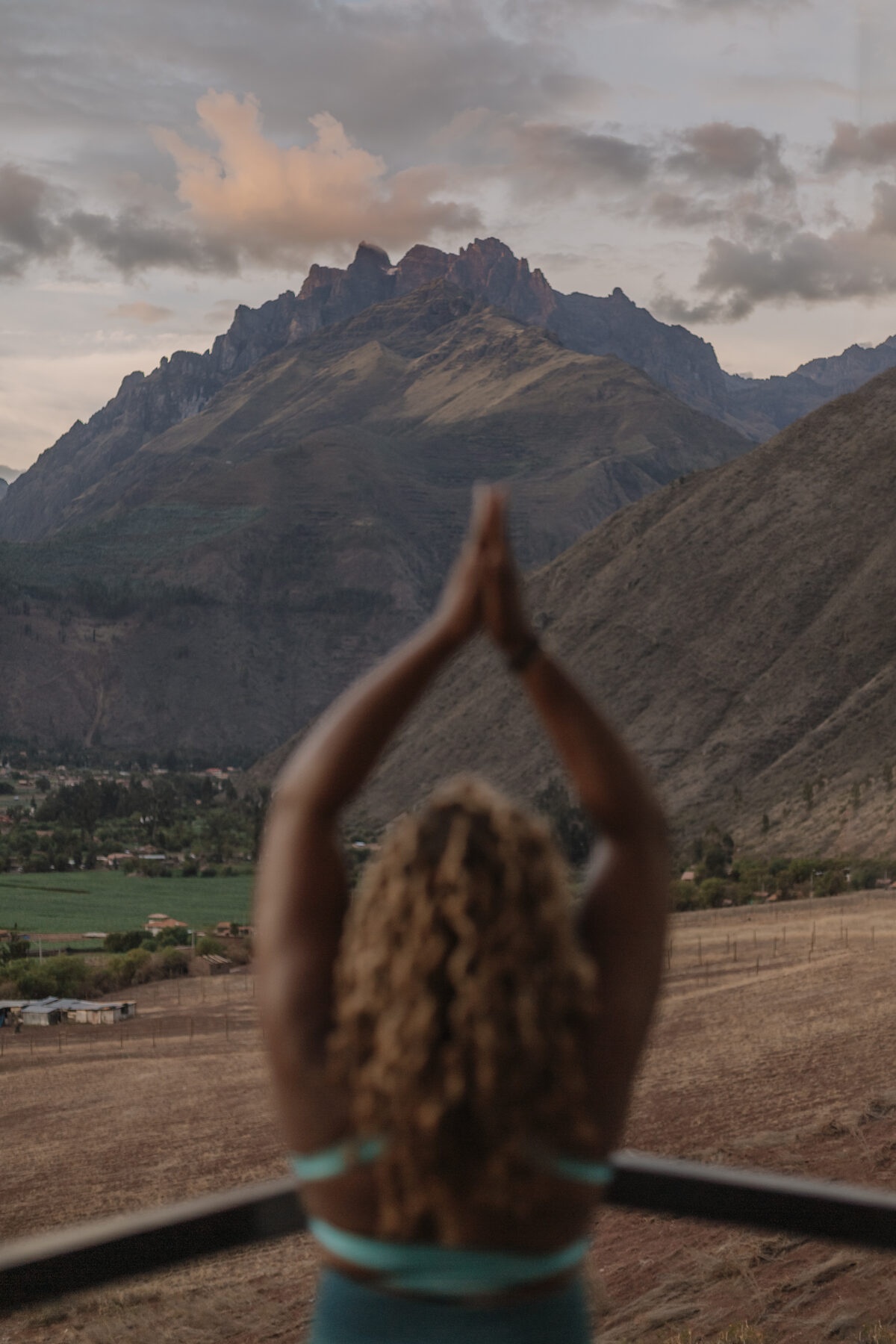 Prayer pose overlooking a mountain valley