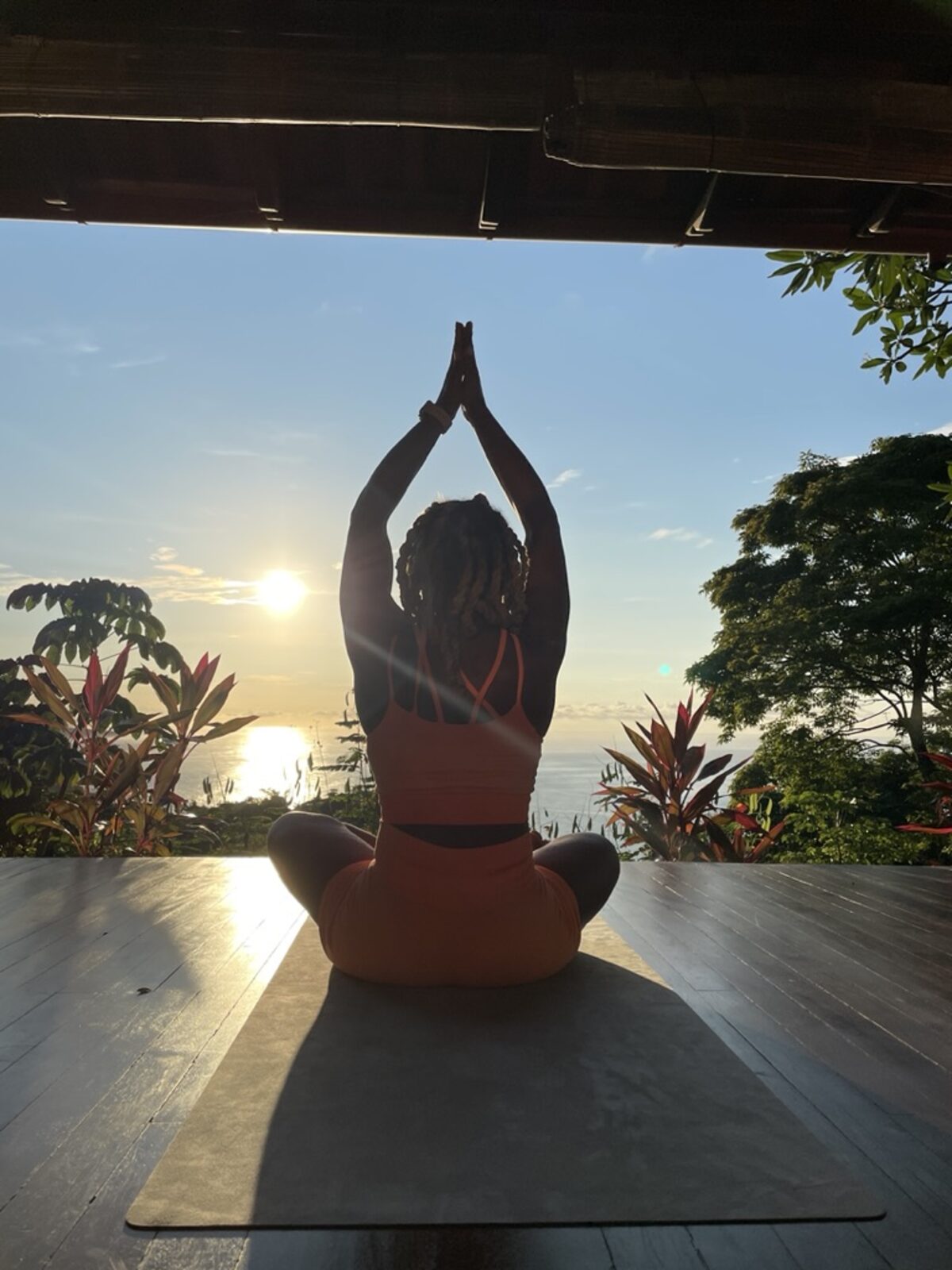 Silhouette in prayer pose at sunset